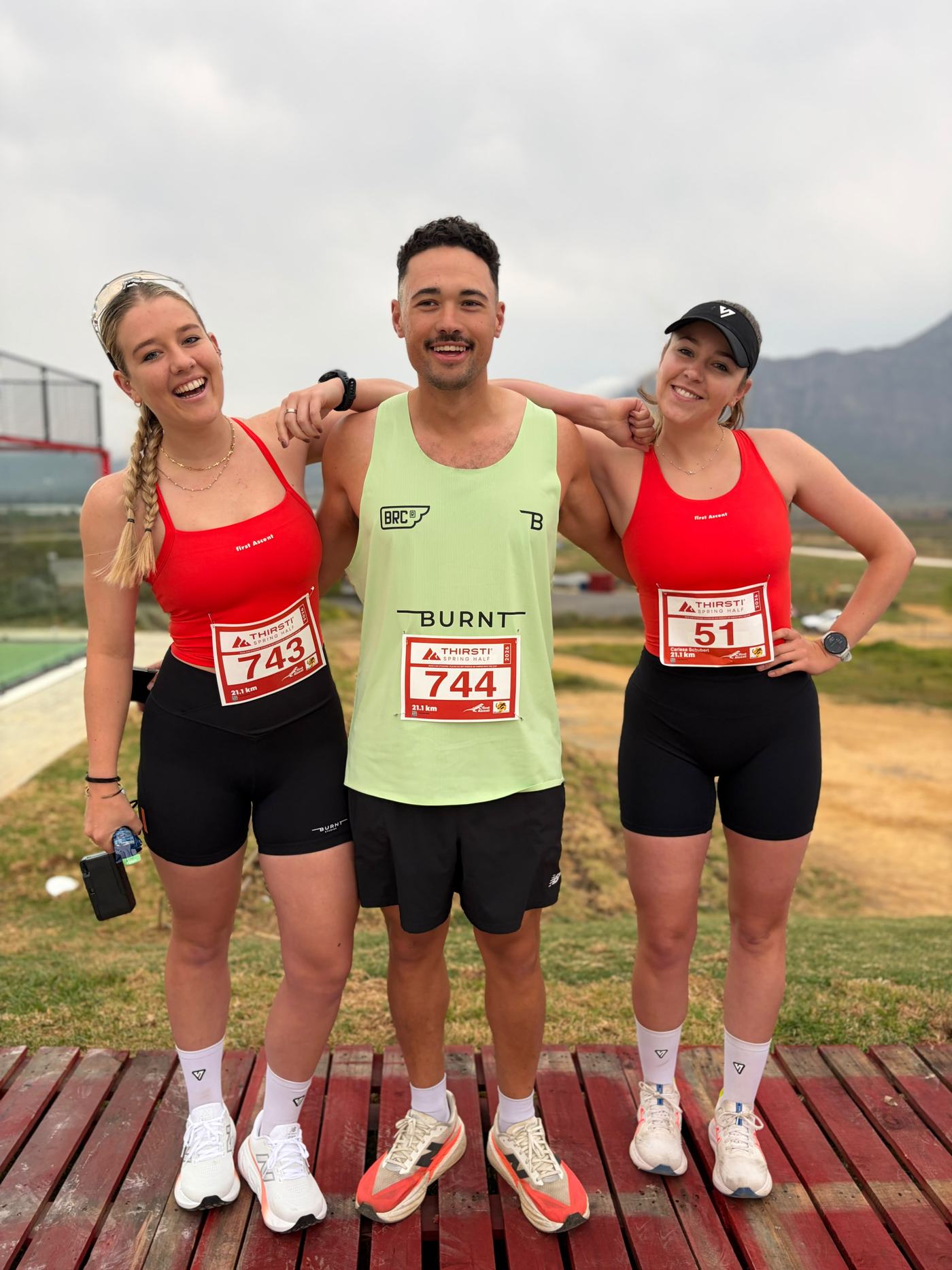 Terrence with two fellow runners after a 21.1 kilometre half marathon, medals around their necks.
