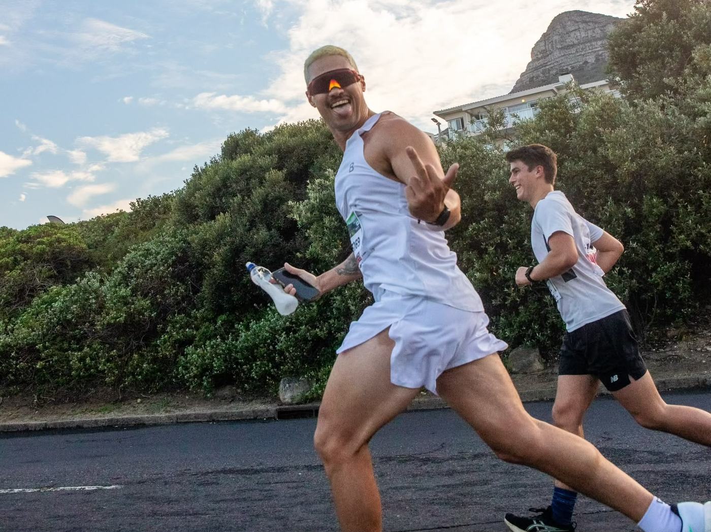 Terrence running on a path with Lion's Head and the Cape Town coastline behind him.